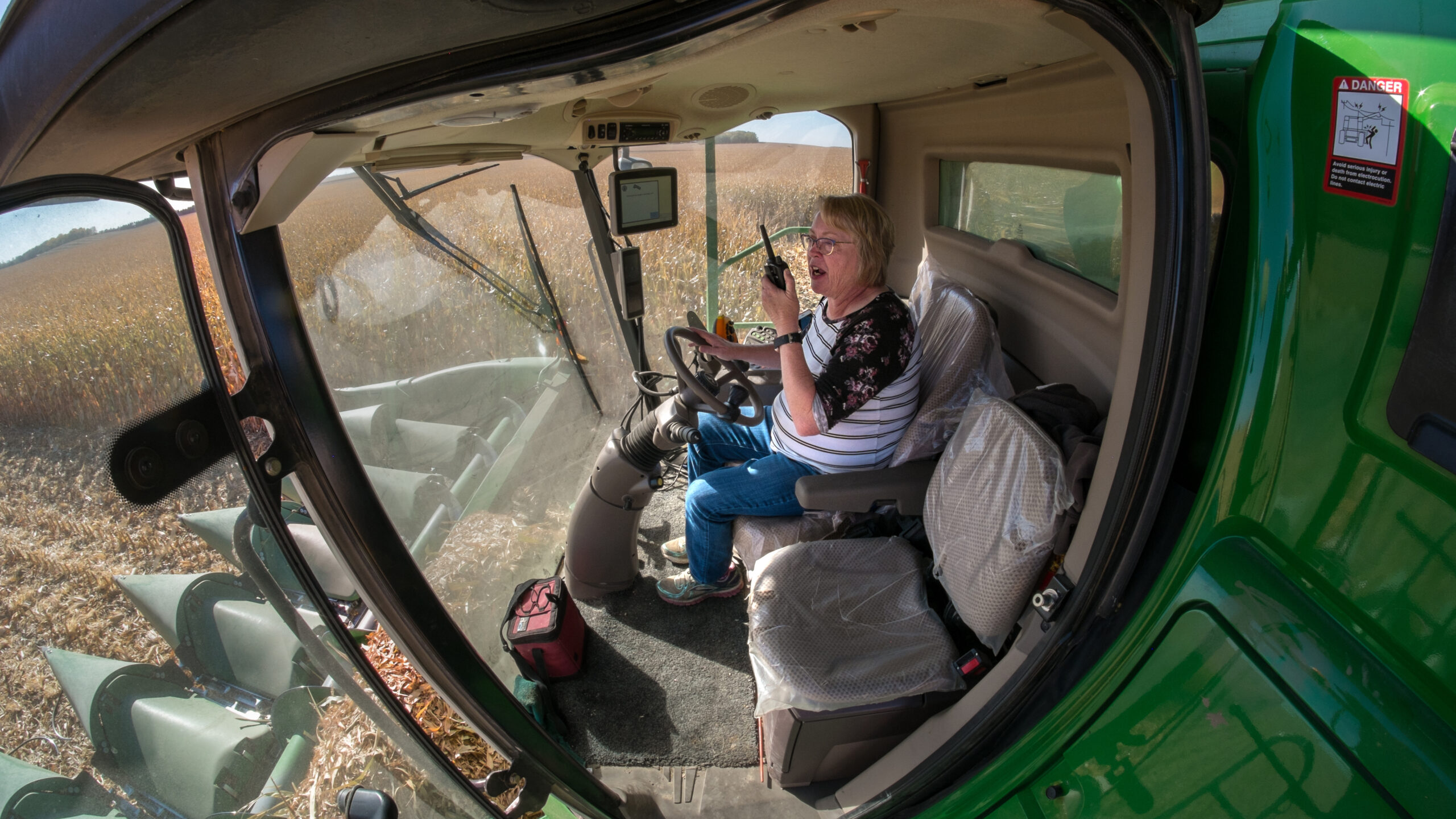 woman harvesting crop talking on radio
